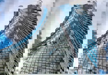 Bild på fönsterputsare som rengör en fasad med många fönster.